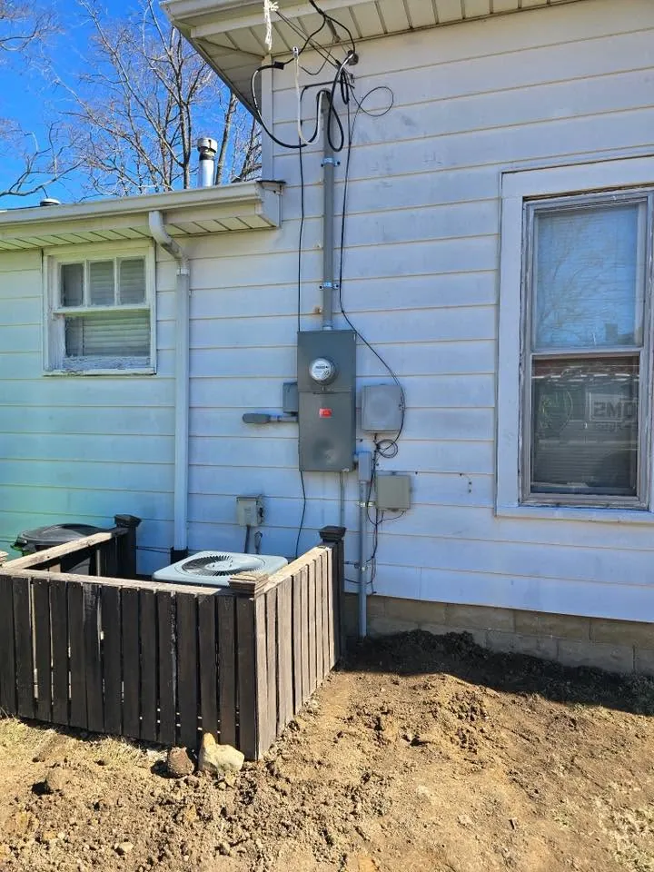 After: a new meter base with a rigid mast and new conduit on the same house
